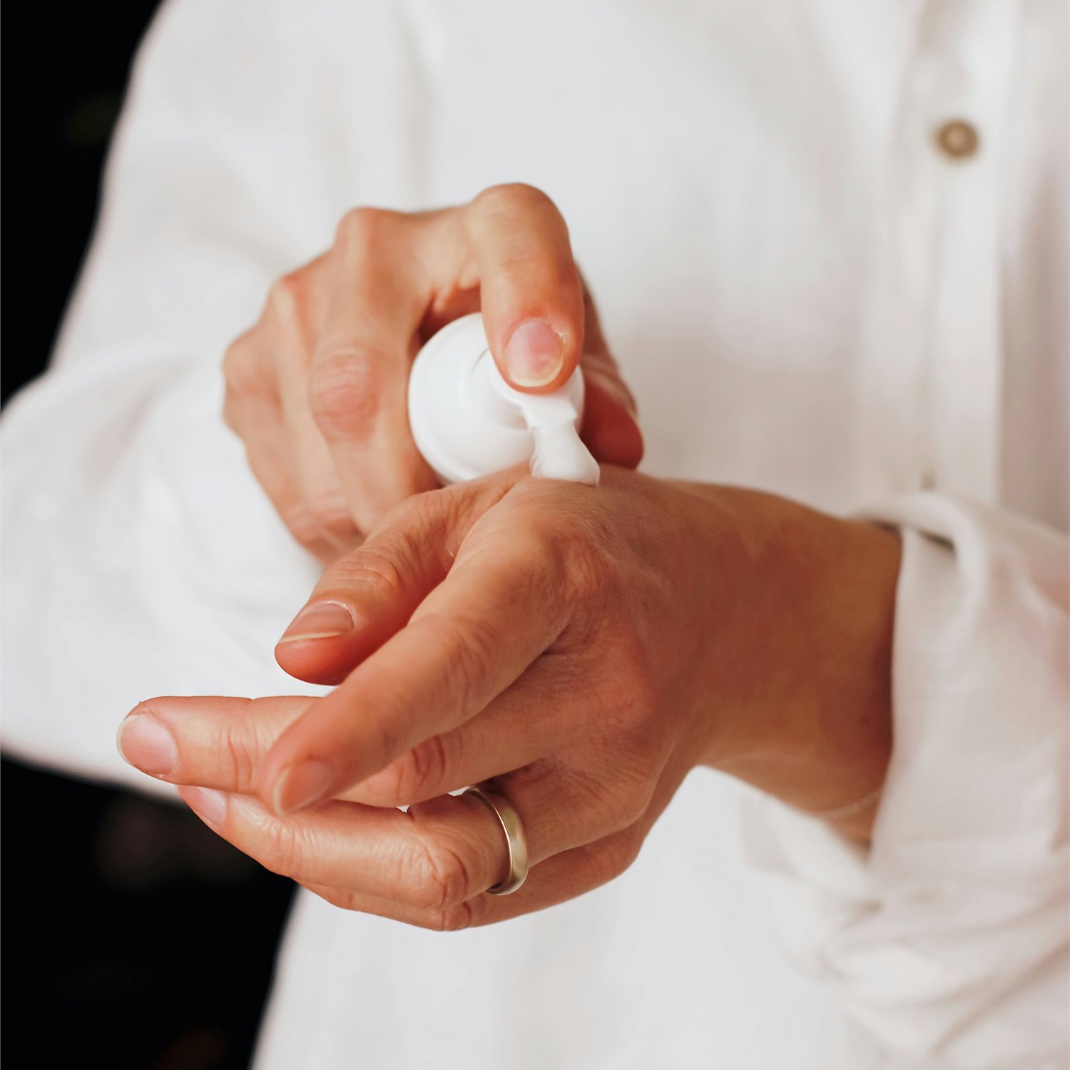 A person applying moisturizer to their hand